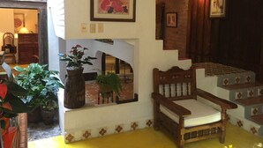 A cozy room with a wooden bench, a staircase with patterned steps, and a potted plant. - Bed and breakfast Bugambilias  (Puerto Vallarta)