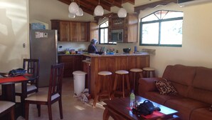 A cozy kitchen with wooden cabinets, a bar area, and a dining setup. - NICE 3 BEDROOM MODERN HOUSE WITH POOL (Sámara)