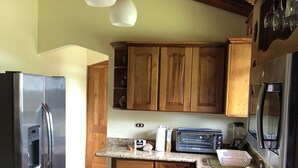 A kitchen with wooden cabinets, stainless steel appliances, and a granite countertop. - NICE 3 BEDROOM MODERN HOUSE WITH POOL (Sámara)