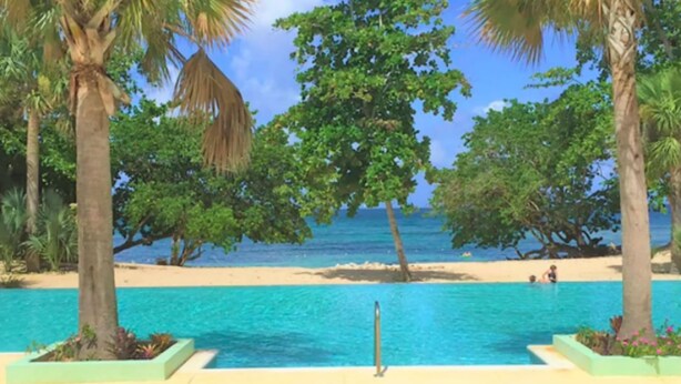 Un espace piscine offrant une vue sur la plage et l’océan.