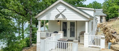 A treehouse with a wooden deck, a small porch, and a sign reading "TREEHOUSE".