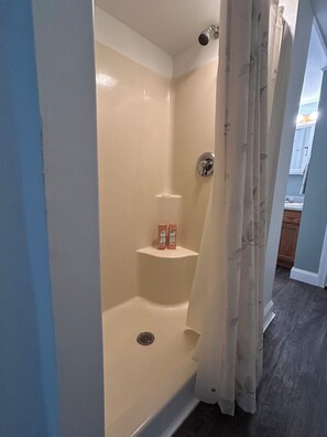 A bathroom with a shower, a toilet, and a sink.