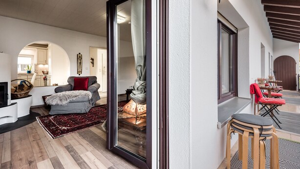 Una sala de estar con chimenea, un sofá, una mesa de centro y un comedor con sillas.