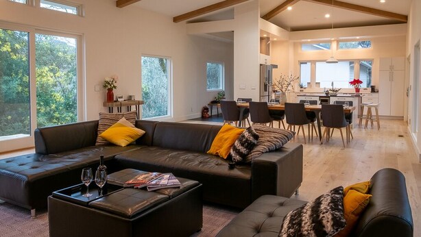 A spacious living area with a modern sofa set, a coffee table with glasses, and a dining area with chairs and a table. - Wake Up in Your Own Private Vineyard - Healdsburg (Healdsburg)