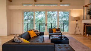 A spacious living room with a large window, a fireplace, and a modern sofa set. - Wake Up in Your Own Private Vineyard - Healdsburg (Healdsburg)
