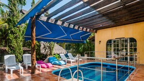 A pool area with a blue umbrella, white lounge chairs, and a tiled deck. - FULL APARTMENT NEAR CANCUN AIRPORT (Alfredo V. Bonfil)