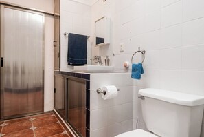 Kylpyhuone, jossa on wc, pesuallas ja peili.