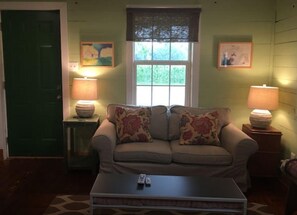 A living room with a sofa, two lamps, a window, and a door. - Historic farmhouse D’Mem 7 Min, ❤️1 Pet free 2nd pet considered for fee  (Mound City)