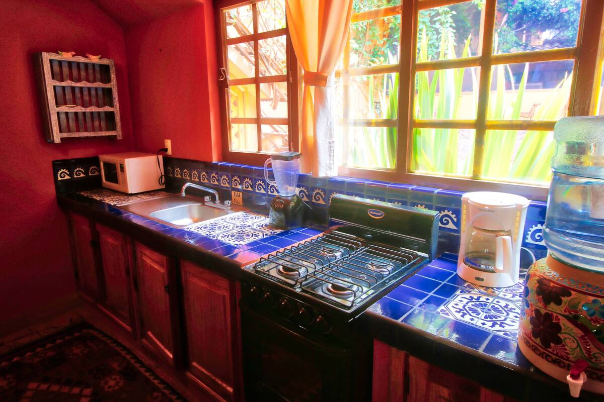 Une cuisine équipée d’une cuisinière à gaz, d’une machine à café et d’un distributeur d’eau.