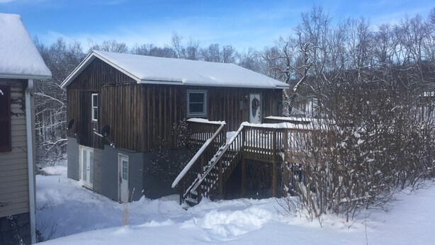 A wooden cabin with a snow-covered roof and a wooden deck. - Coal Miner's Cabin - Near Winterplace, Beckley and Princeton (Shady Spring)