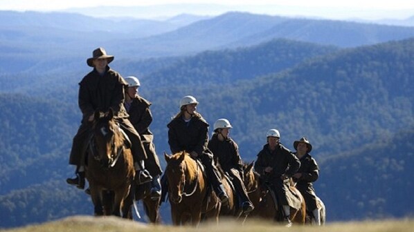 A group of people on horseback in a mountainous area.