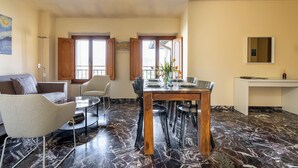 Ein Essbereich mit Marmorboden, einem Holztisch und modernen Stühlen.