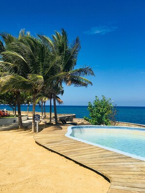 An infinity pool, sun loungers - Gorgeous Ocean Front Luxury Apartment - 2 bed/2 bath at Whispering Seas (Tower Isle)