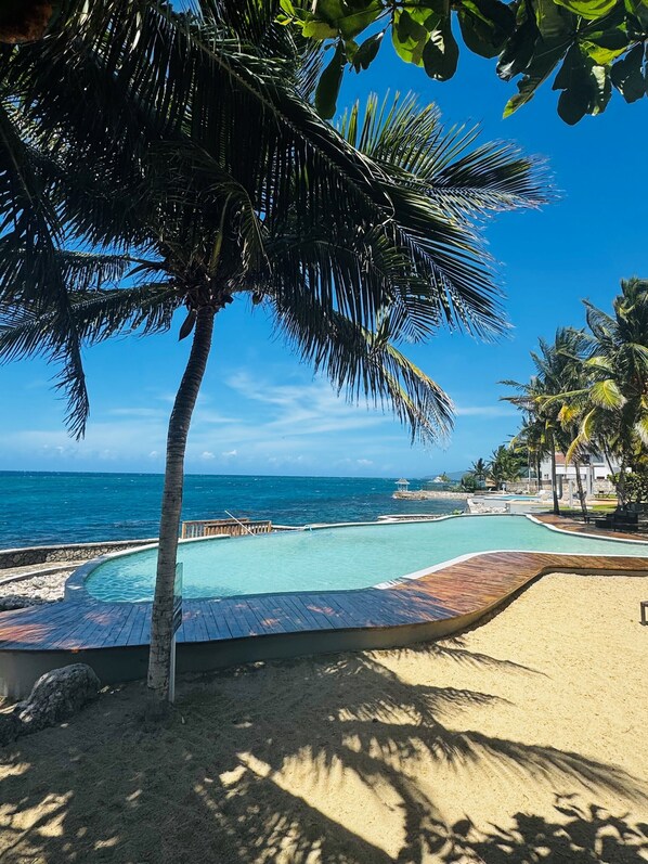 An infinity pool, sun loungers - Gorgeous Ocean Front Luxury Apartment - 2 bed/2 bath at Whispering Seas (Tower Isle)