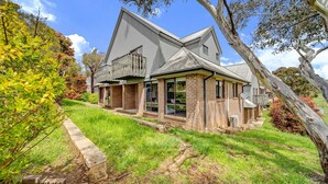 A two-story house with a large front porch, brick exterior, and a sloped roof. - Petersdorf 2 - Modern 2BR Townhouse l WiFi l Mountain Views (Jindabyne)