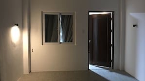 A hallway with a door, a window with curtains, and a wall-mounted light fixture. - Mayumi Lodge, Perfect for couples. Cozy and Nice! Fast Internet (Puerto Princesa)