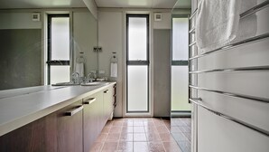 A modern bathroom with a large mirror, a sink, and a towel rack. - Ecocrackenback 2 'Sustainable chalet close to the slopes.' (Crackenback)