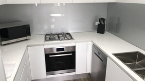 Eine moderne Küche mit Mikrowelle, Gasherd, Backofen und Geschirrspüler.