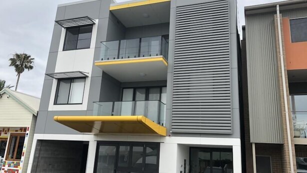 Ein mehrstöckiges Gebäude mit Balkonen, großen Fenstern und einem modernen architektonischen Design.