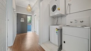 Ein Waschraum mit Waschmaschine, Trockner und Warmwasserbereiter.
