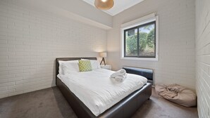 Une chambre à coucher avec un lit, une fenêtre et une lampe.
