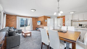 A modern apartment with a living room, dining area, and kitchen.