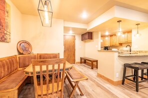A modern kitchen with wooden cabinets, a built-in island, and pendant lighting.
