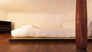 Ein Schlafzimmer mit einem Bett, einem Holz-Kopfteil und Holzboden.