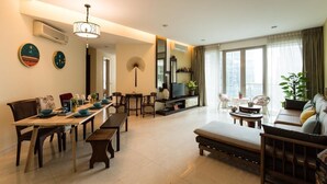 A spacious living area with a dining table, sofas, and a TV. - Elysees Suite Marc Residence KLCC (Kuala Lumpur)