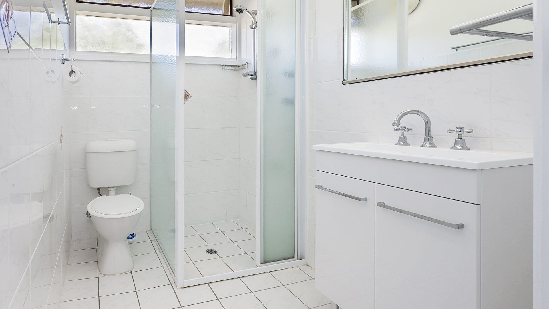 Une salle de bain moderne équipée de toilettes, d’une douche et d’un lavabo.