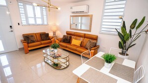 Una sala moderna con sofá, mesa de centro y comedor.