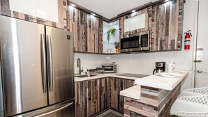 Una cocina moderna con armarios de madera, electrodomésticos de acero inoxidable y una pequeña isla con pileta.