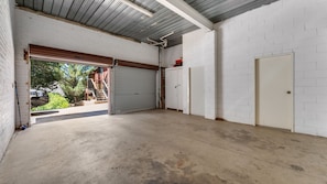 Eine Garage mit Betonboden, weißen Backsteinwänden und einem Metalldach.