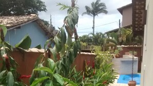 Un jardín cuidado con diversas plantas y un sendero despejado que lleva a la zona de la piscina.
