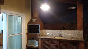 Una cocina con horno empotrado, un lavabo y una lámpara colgante.