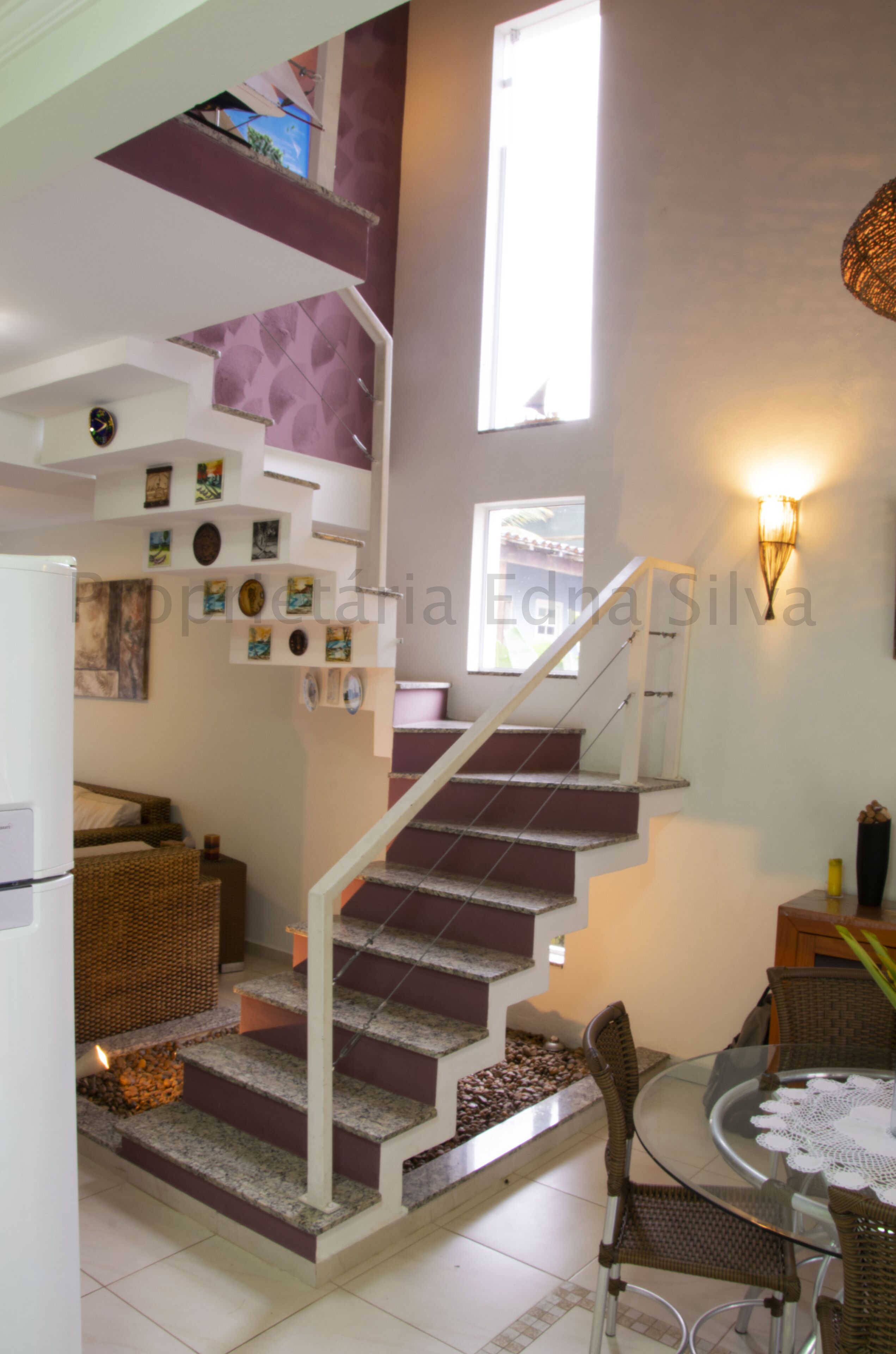 A staircase leading to a second floor with a dining area below.