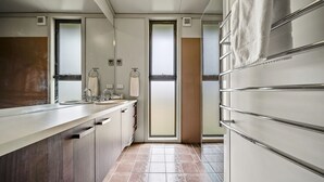 A modern bathroom with a large mirror, a sink, and a towel rack. - Ecocrackenback 16 'Sustainable chalet close to the slopes.' (CRACKENBACK)