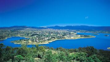 A coastal town with a central body of water, surrounded by hills and a clear sky.