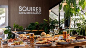 Un restaurant proposant une variété de plats et de boissons, avec une enseigne indiquant : « SQUIRES BAR & BEER GARDEN ».