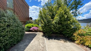 A pathway leading to a building with a sloped roof and a satellite dish. - Seeblick 3 - 1BR Lakefront Apartment l Central Location l Off Street Parking (JINDABYNE)