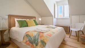 A bedroom with a bed, a desk, a chair, a lamp, and a window. - Cardal Deluxe Apartment (Lisboa ciudad)