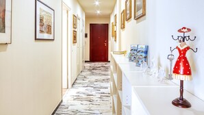 A hotel hallway with framed pictures on the walls, a marble floor, and a mannequin dressed in a red dress. - Giulia Levanto - for 4, in centre, 5 minutes from beach and station to Cinque Terre (Levanto)