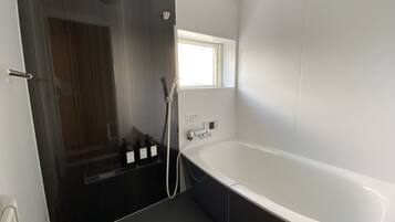 A modern bathroom with a walk-in shower, a standalone bathtub, and a window providing natural light.
