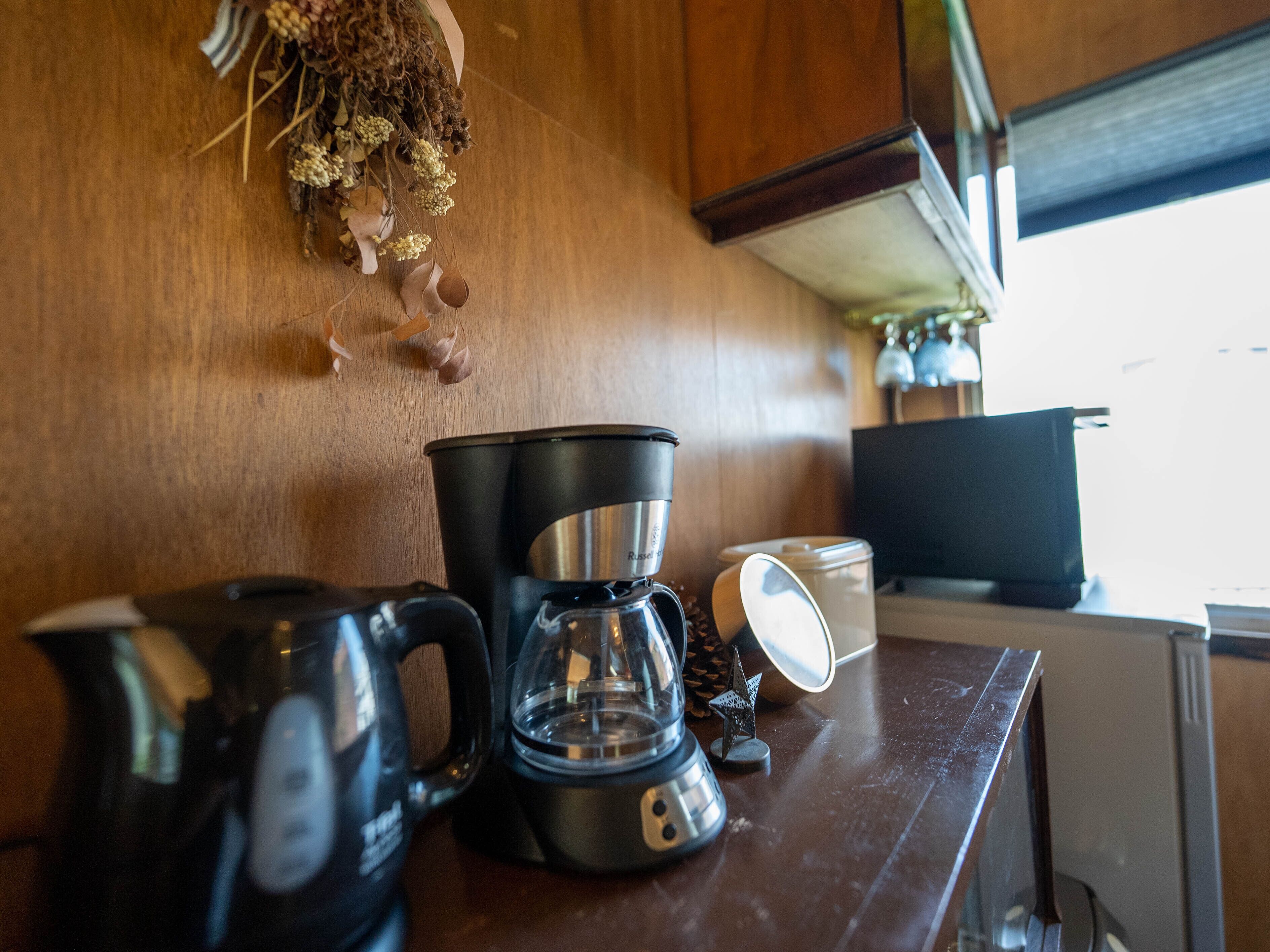 A kitchen counter with a coffee maker, a kettle, and a glass carafe.