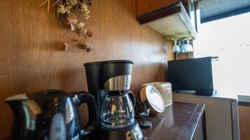 A kitchen counter with a coffee maker, a kettle, and a glass carafe.