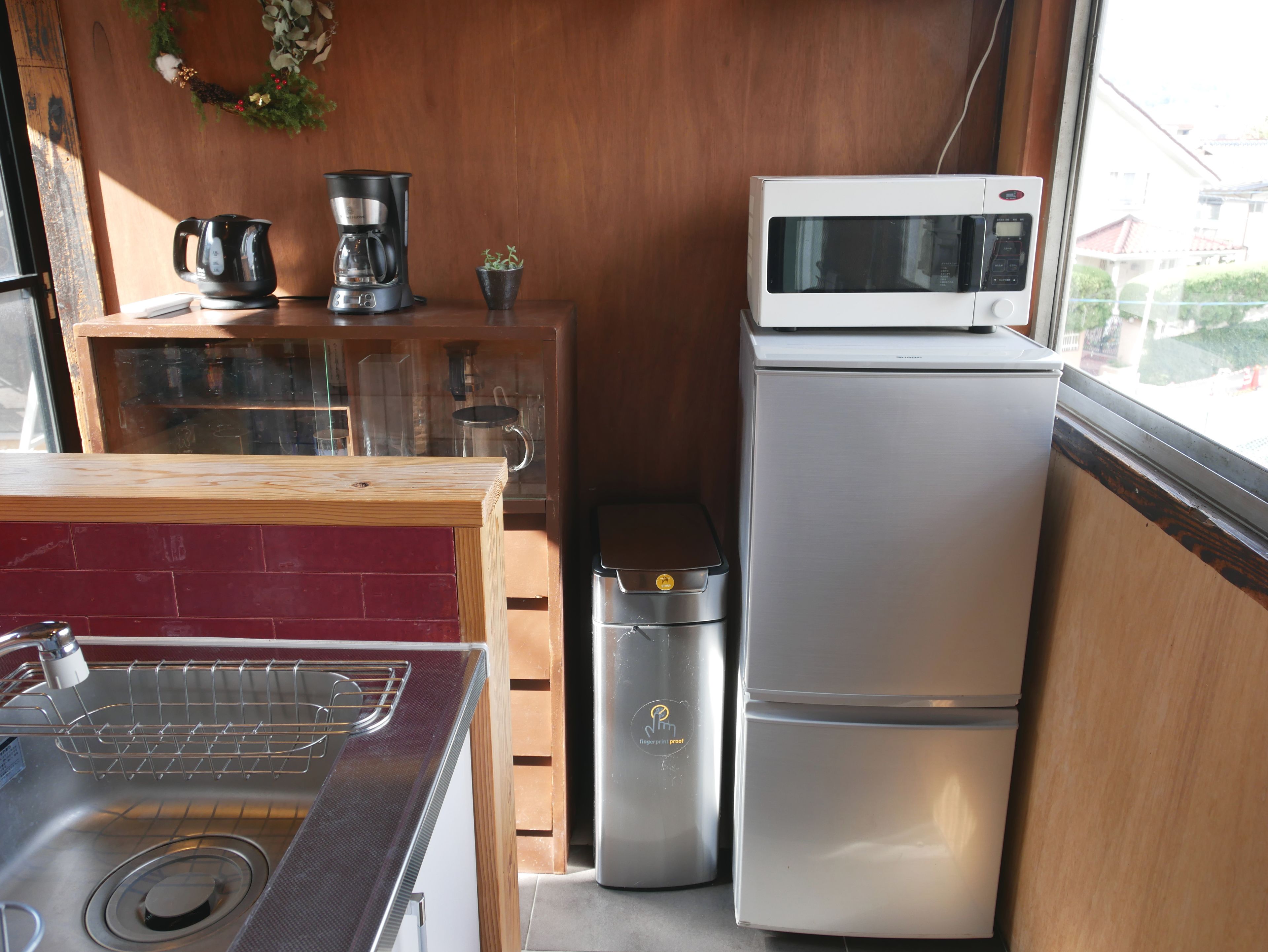 A compact kitchen with a stainless steel sink, a microwave, and a refrigerator.