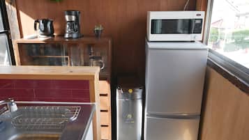 A compact kitchen with a stainless steel sink, a microwave, and a refrigerator.