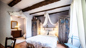 Une chambre à coucher avec un lit, une tête de lit en bois et une table de chevet avec une lampe.
