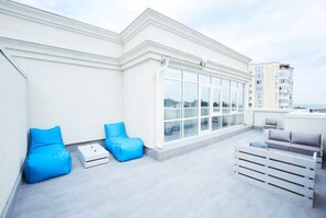 Enjoy expansive city views from this rooftop terrace with a flat roof and large glass wall.