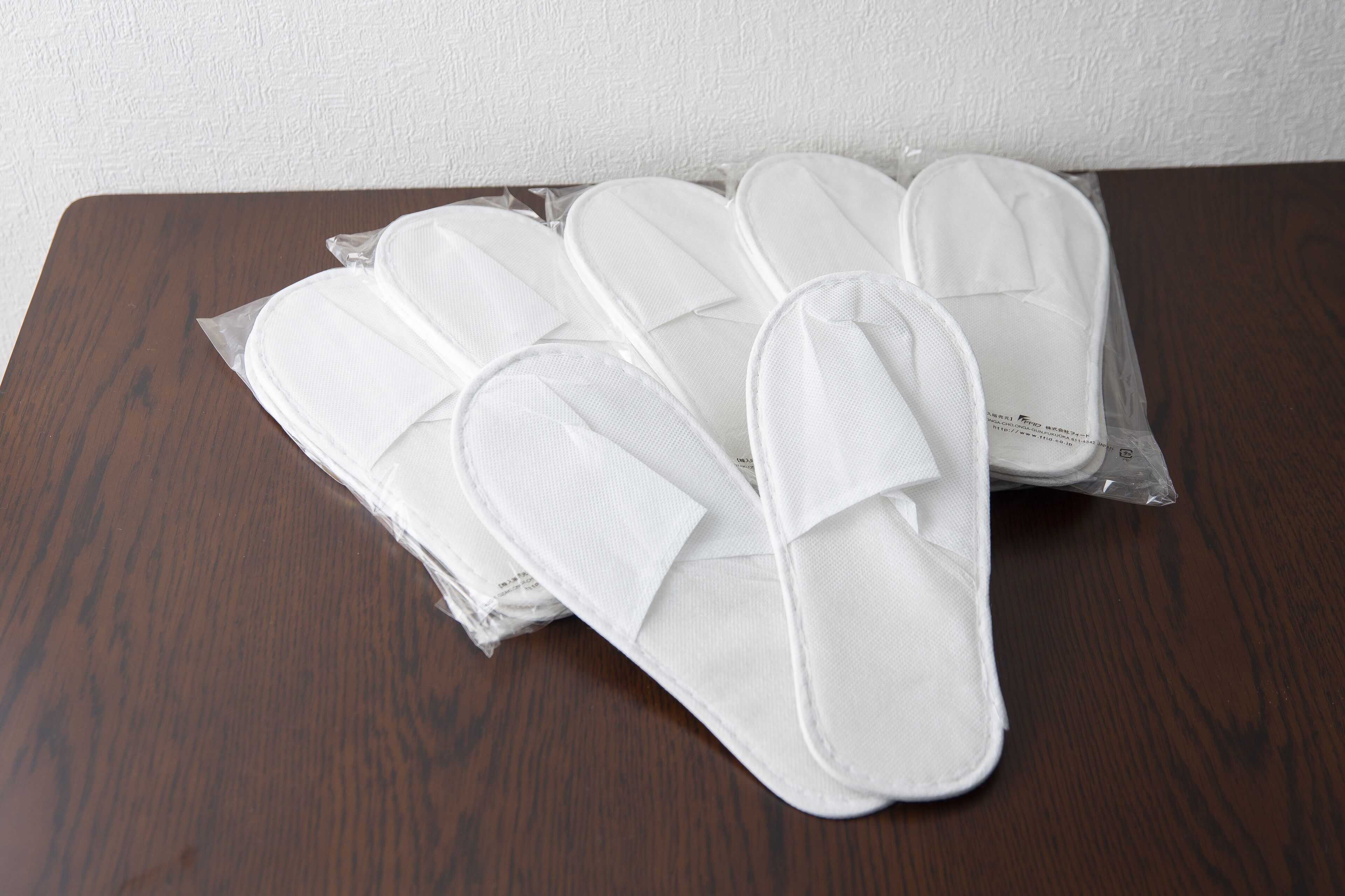 Un juego de pantuflas blancas sobre una mesa de madera.